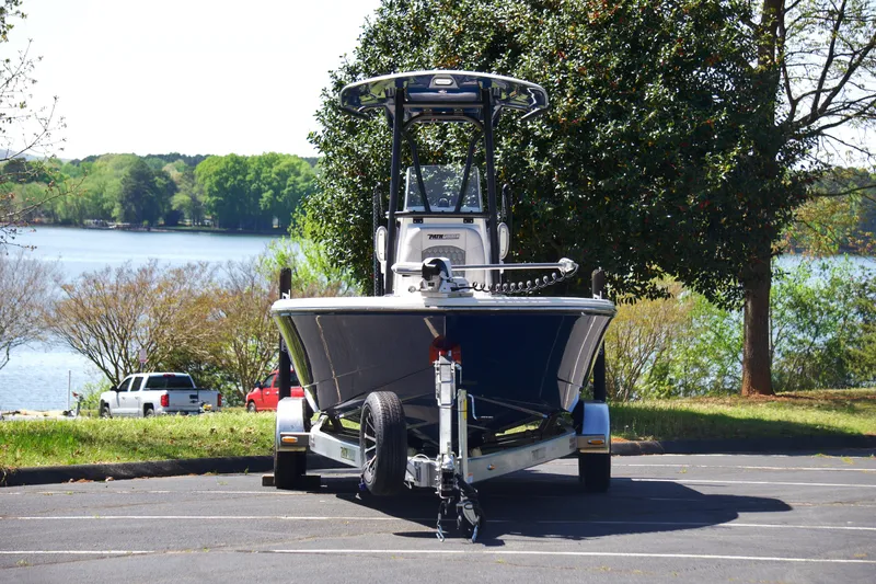 Slide: The Image of 2025 Pathfinder 2500 Hybrid boat on trailer, parked near a scenic lake. - 6