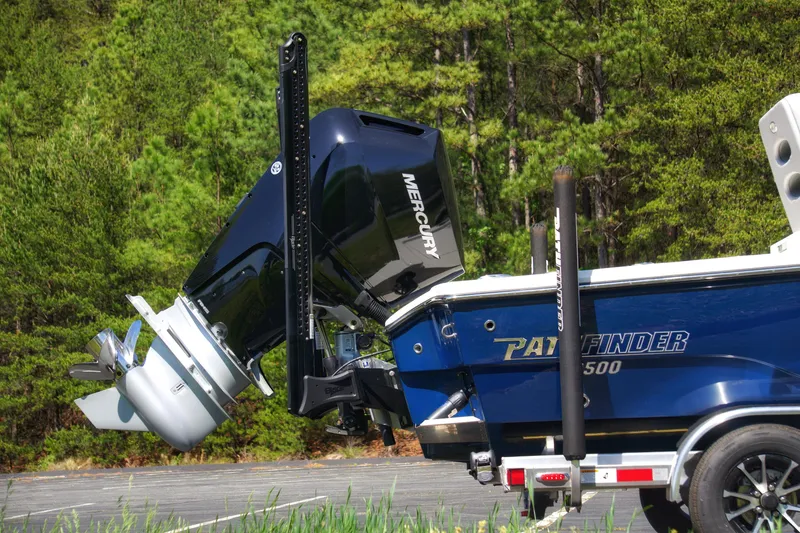 Slide: The Image of 2025 Pathfinder 2500 Hybrid boat with Mercury engine, parked in a wooded area. - 8