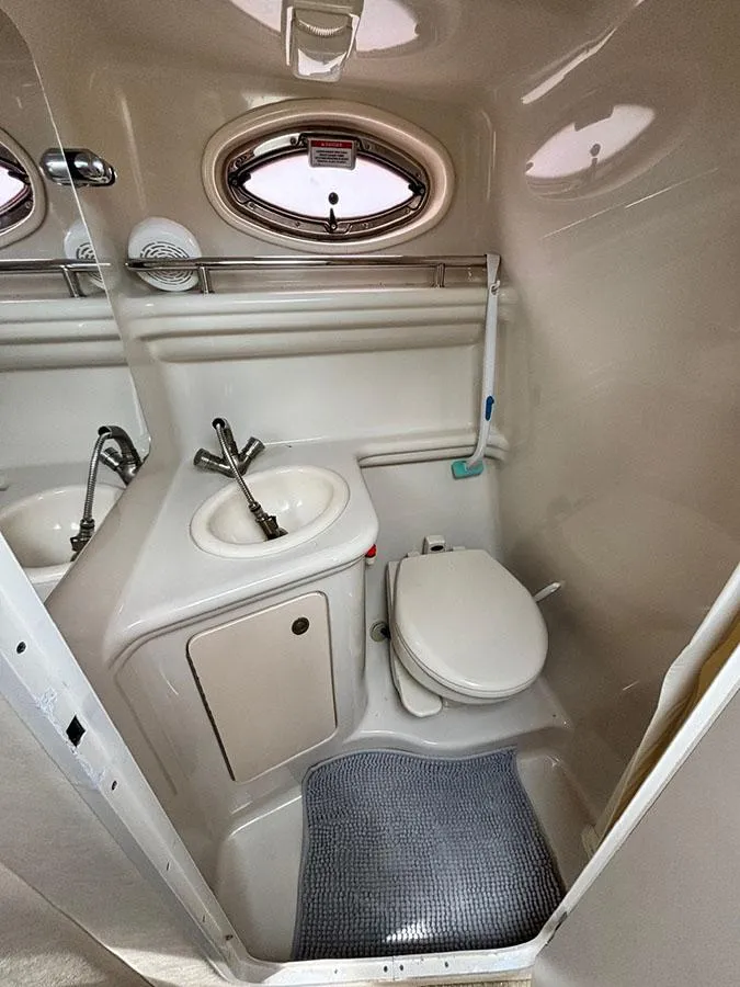 Slide: The Image of Compact bathroom in 2007 Sea Ray 260 Sundancer boat with sink, toilet, and porthole window. - 11