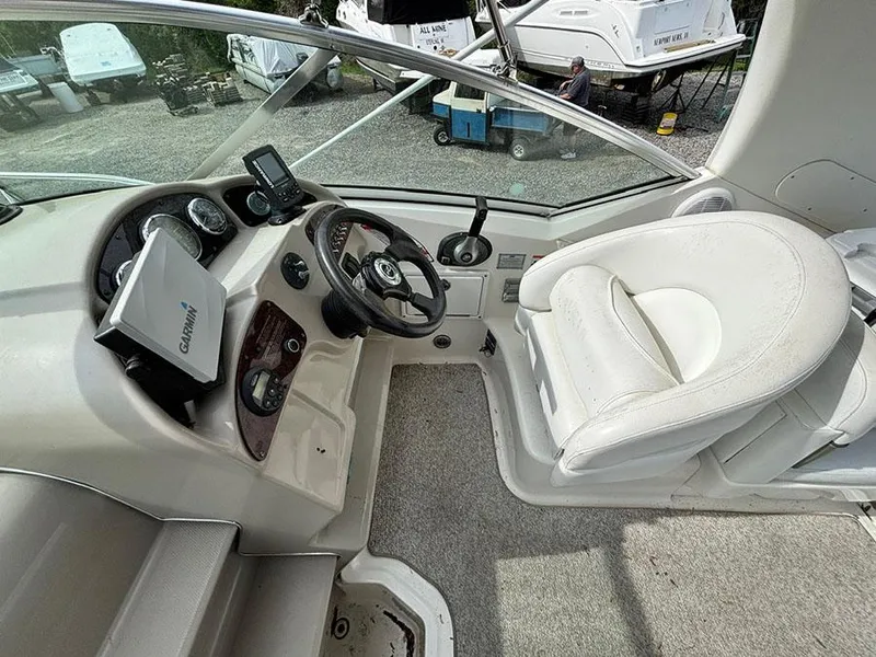 Slide: The Image of 2007 Sea Ray 260 Sundancer helm with steering wheel, gauges, and white captain's chair. - 16