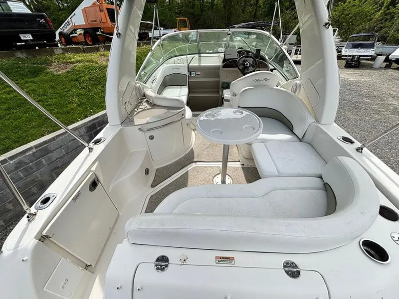 Slide: The Image of 2007 Sea Ray 260 Sundancer boat interior with seating and table, parked outdoors. - 19
