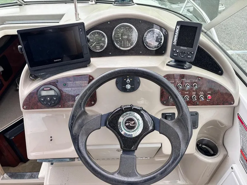 Slide: The Image of 2007 Sea Ray 260 Sundancer helm with steering wheel, gauges, and navigation equipment. - 2