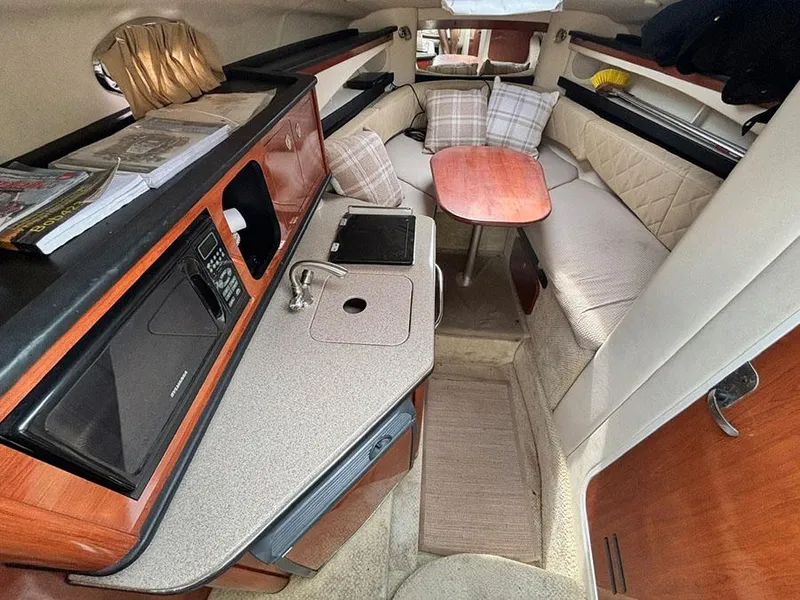 Slide: The Image of 2007 Sea Ray 260 Sundancer cabin interior with kitchenette, seating, and table. - 9