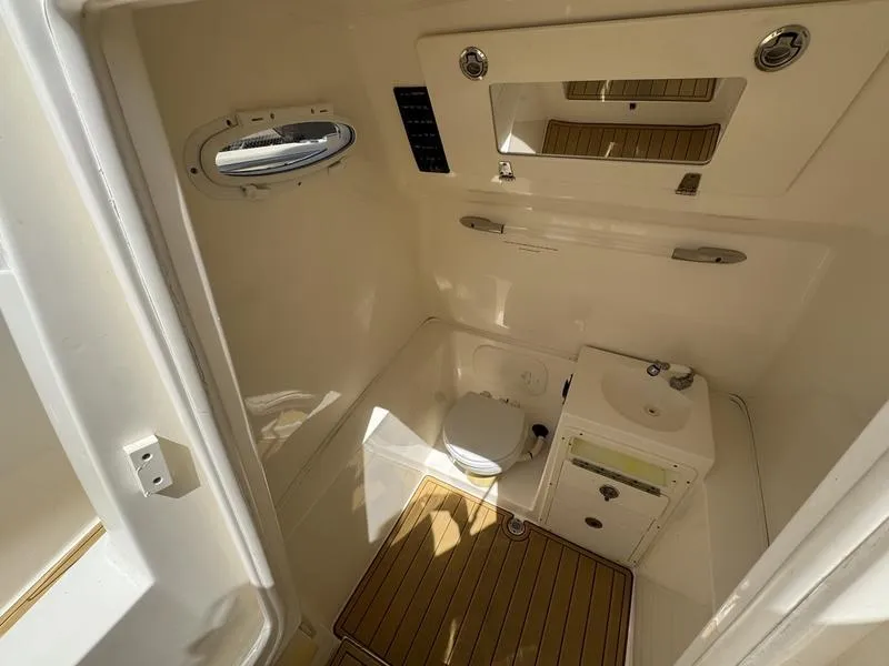Slide: The Image of 2016 Cobia 296 Center Console boat interior with toilet and sink. - 13