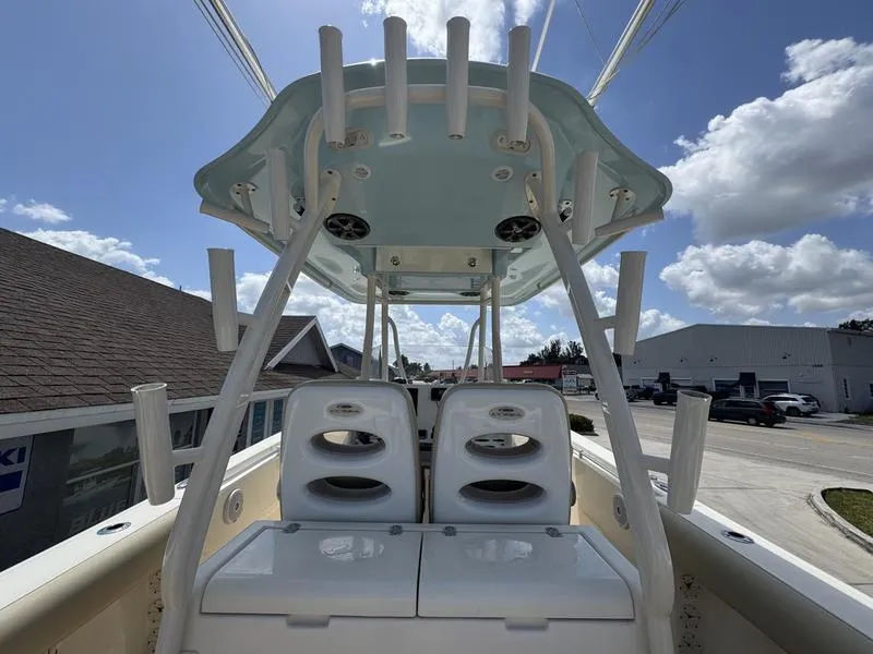 Slide: The Image of 2016 Cobia 296 Center Console boat with dual seats and rod holders under a blue sky. - 17