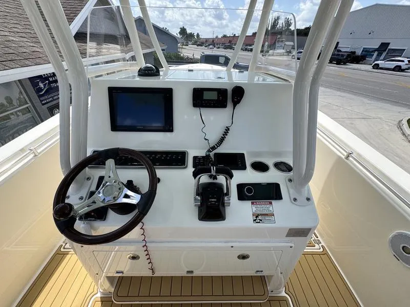 Slide: The Image of 2016 Cobia 296 Center Console boat dashboard with steering wheel and navigation equipment. - 19