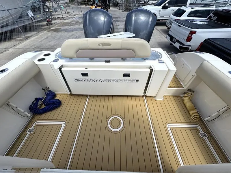 Slide: The Image of 2016 Cobia 296 Center Console boat deck with twin engines and seating. - 20