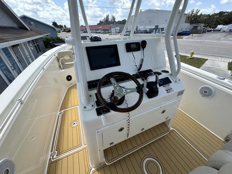 Slide: The Image of 2016 Cobia 296 Center Console boat interior with steering wheel and navigation equipment. - 21