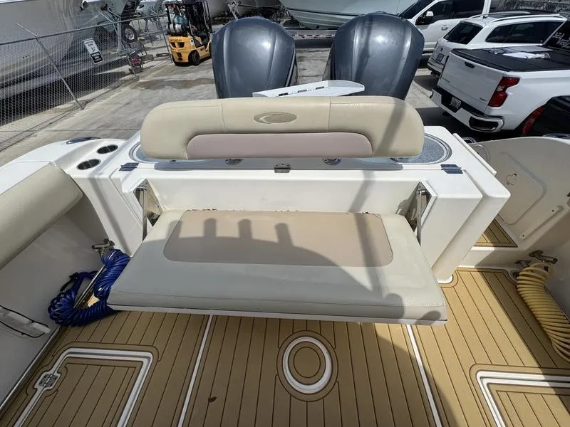 Slide: The Image of 2016 Cobia 296 Center Console boat with foldable seating and twin engines, docked outdoors. - 22