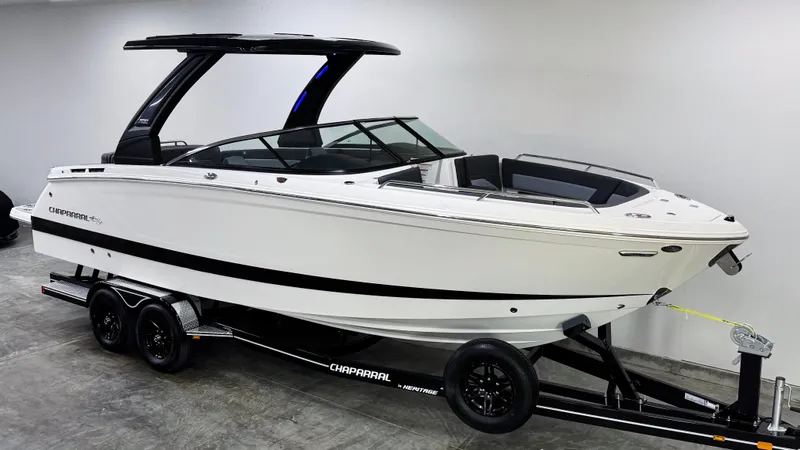 Slide: The Image of 2025 Chaparral 2870 SSX boat on trailer, sleek white design, modern features. - 2
