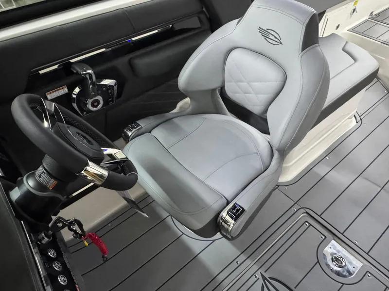 Slide: The Image of 2025 Chaparral 2870 SSX boat interior with sleek gray captain's seat and modern steering wheel. - 22