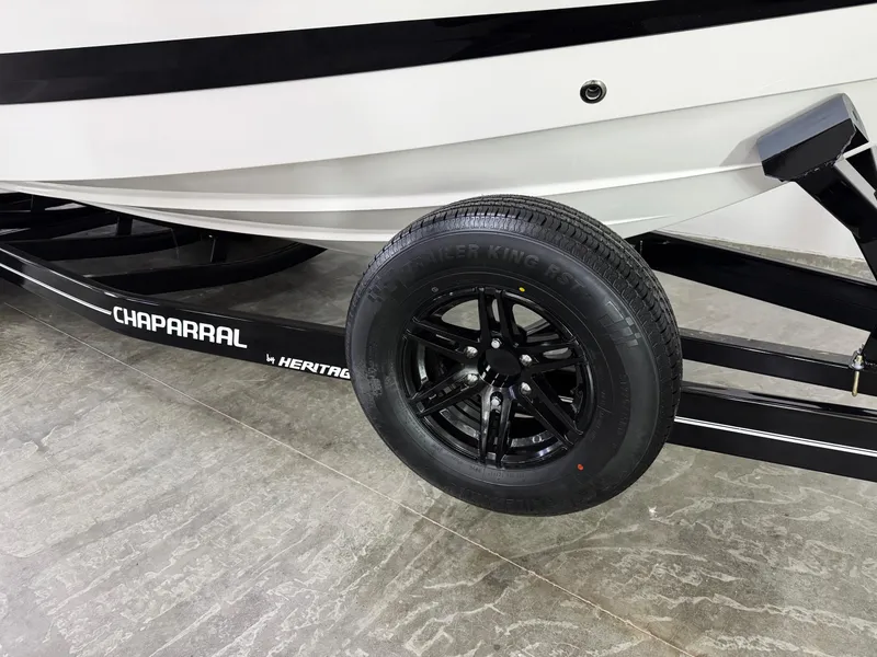 Slide: The Image of 2025 Chaparral 2870 SSX boat on trailer with black wheel and Chaparral branding. - 48
