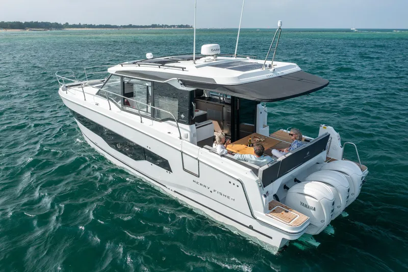 Slide: The Image of 2025 Jeanneau NC 1295 Coupe cruising on open water with passengers enjoying the deck. - 3