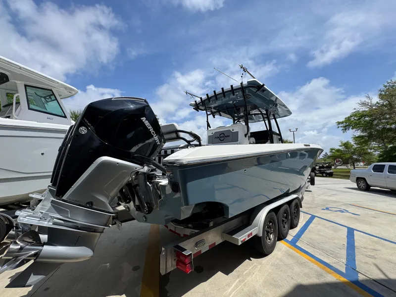 Slide: The Image of 2021 Fountain 38TE boat on trailer, parked outdoors under a partly cloudy sky. - 14
