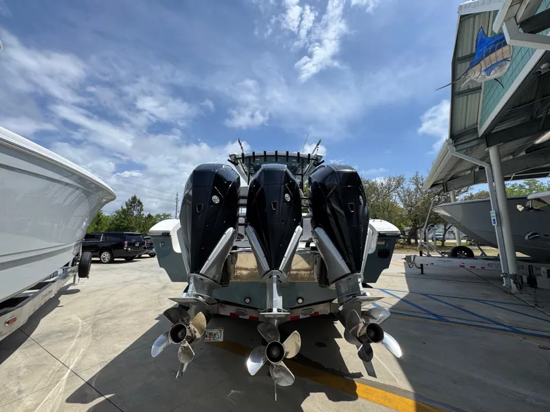 Slide: The Image of 2021 Fountain 38TE boat with triple outboard engines in a marina setting. - 16