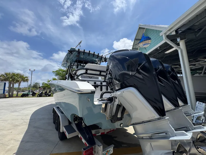 Slide: The Image of 2021 Fountain 38TE boat with powerful outboard engines, parked outdoors under a clear sky. - 17