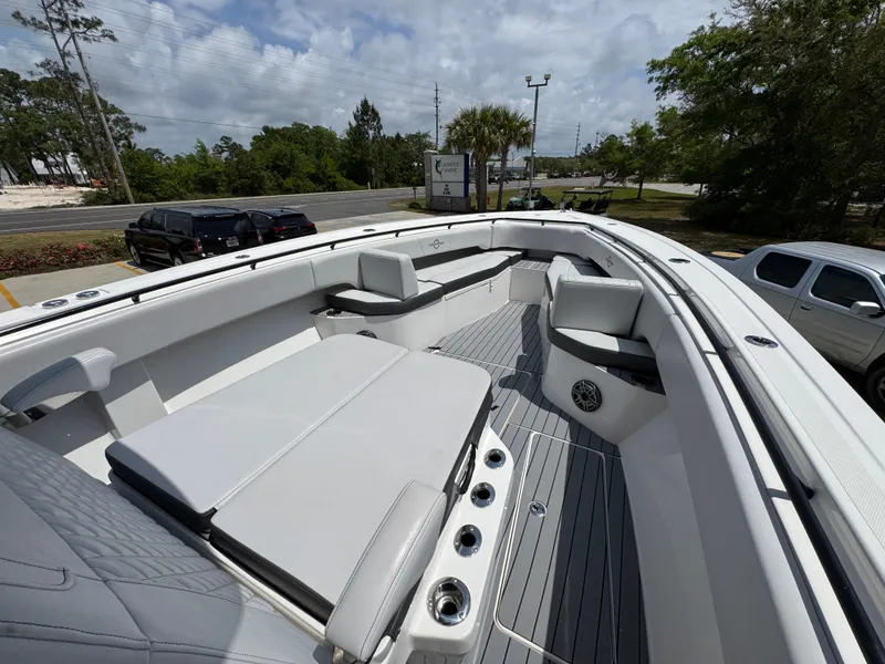 Slide: The Image of 2021 Fountain 38TE boat with spacious seating and sleek design, parked outdoors. - 18