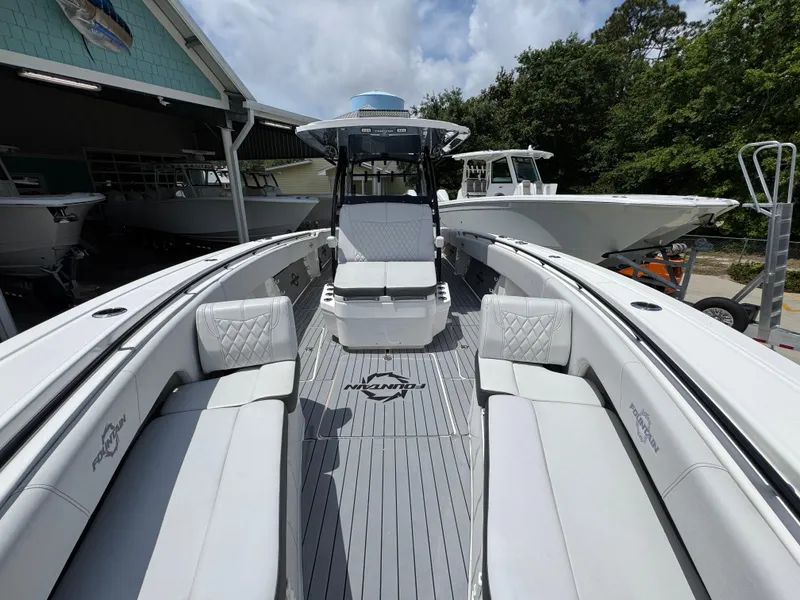 Slide: The Image of 2021 Fountain 38TE boat with spacious seating and sleek design in a marina setting. - 22
