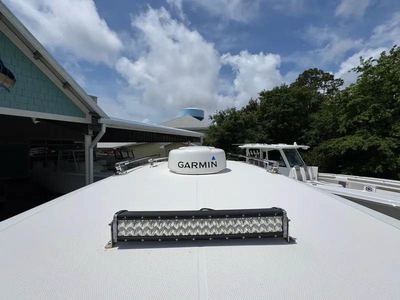 Slide: The Image of 2021 Fountain 38TE boat with Garmin radar, docked under a cloudy sky. - 24