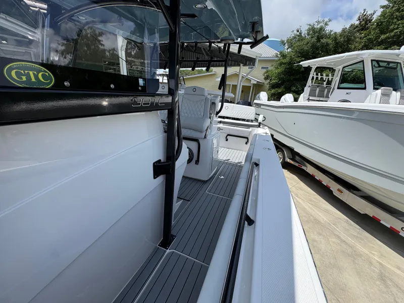 Slide: The Image of 2021 Fountain 38TE boat, sleek design, docked beside another vessel, sunny day. - 26