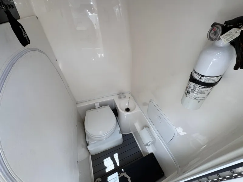 Slide: The Image of 2021 Fountain 38TE boat bathroom with toilet, fire extinguisher, and white interior. - 28