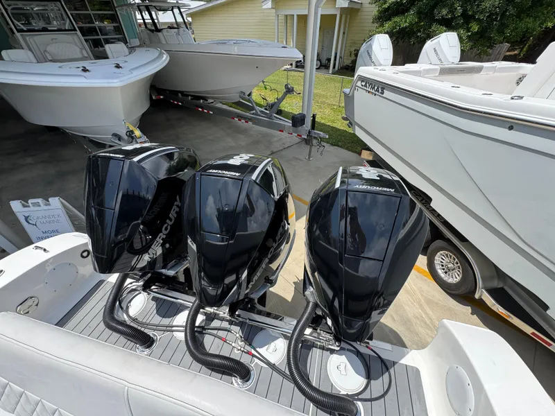 Slide: The Image of Triple Mercury outboard engines on a 2021 Fountain 38TE boat, docked with other vessels. - 41