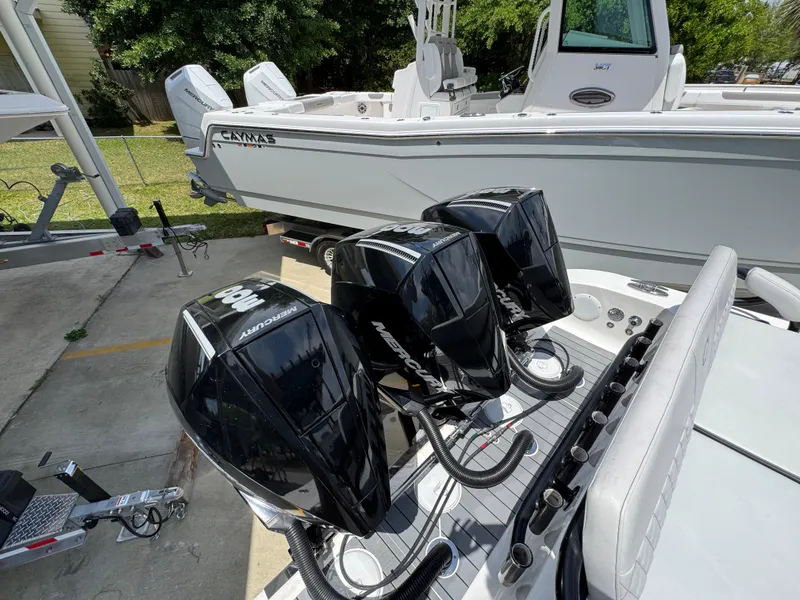 Slide: The Image of Triple outboard motors on a 2021 Fountain 38TE boat, parked near a trailer. - 42