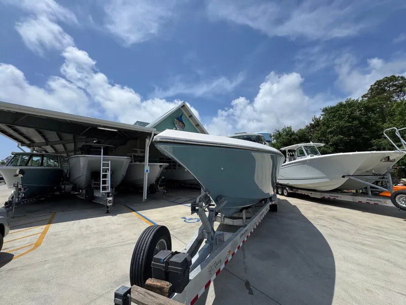 Slide: The Image of 2021 Fountain 38TE boat on trailer under clear blue sky at a marina. - 6