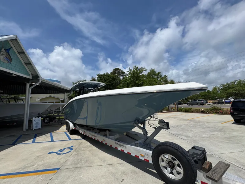 Slide: The Image of 2021 Fountain 38TE boat on trailer, parked outdoors under a cloudy sky. - 8