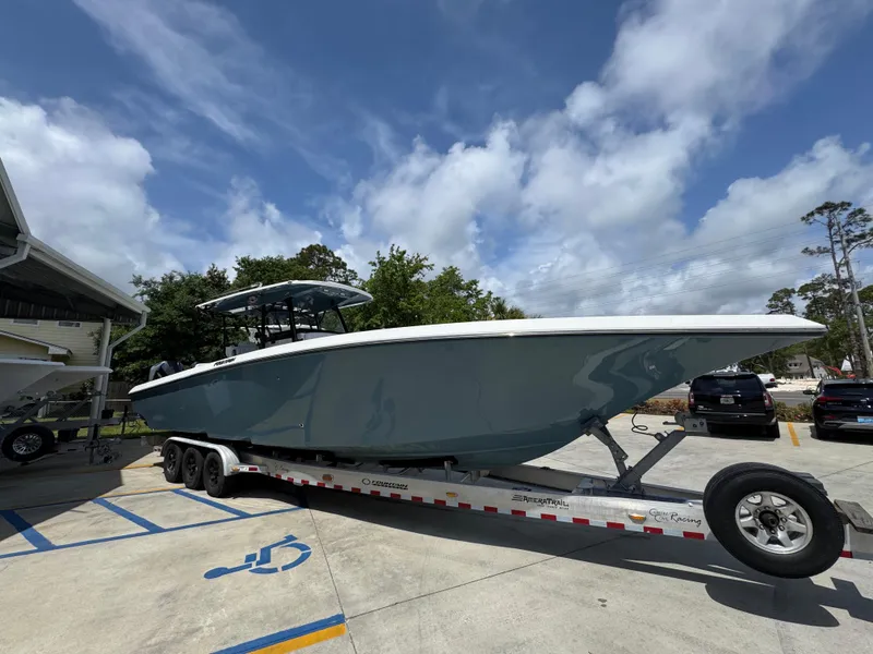 Slide: The Image of 2021 Fountain 38TE boat on trailer, parked outdoors under a cloudy sky. - 9