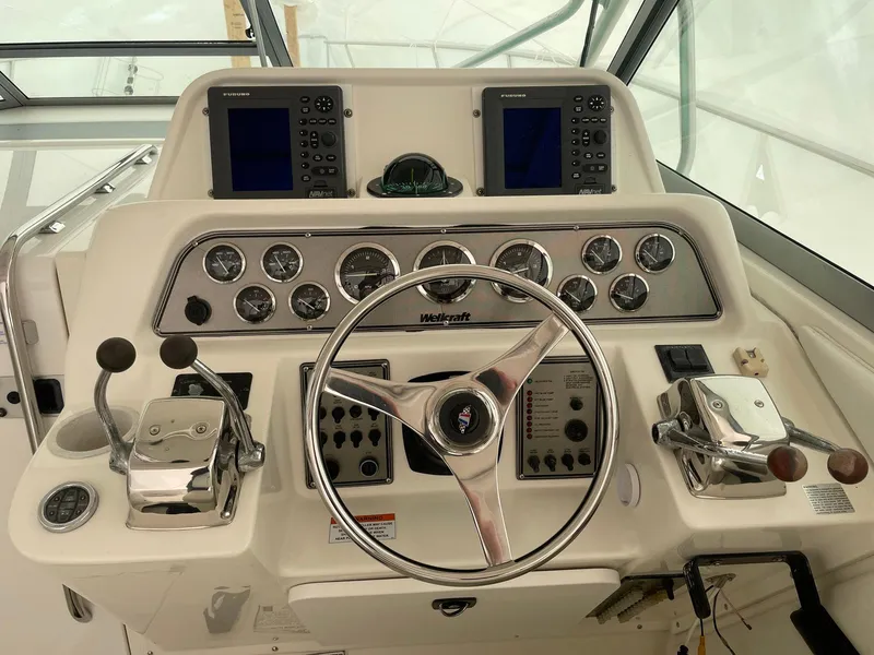 Slide: The Image of Control panel of a 2000 Wellcraft 330 Coastal boat with steering wheel and gauges. - 15