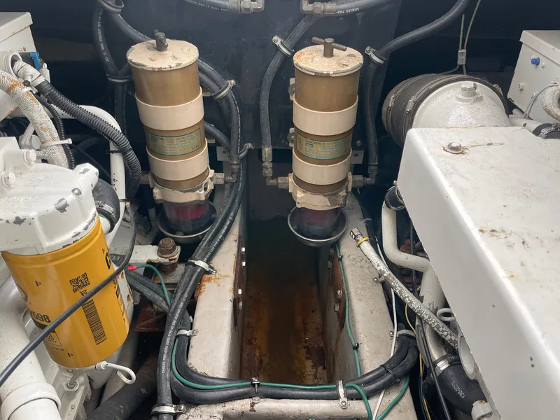 Slide: The Image of Engine compartment of a 2000 Wellcraft 330 Coastal boat, showing filters and hoses. - 21