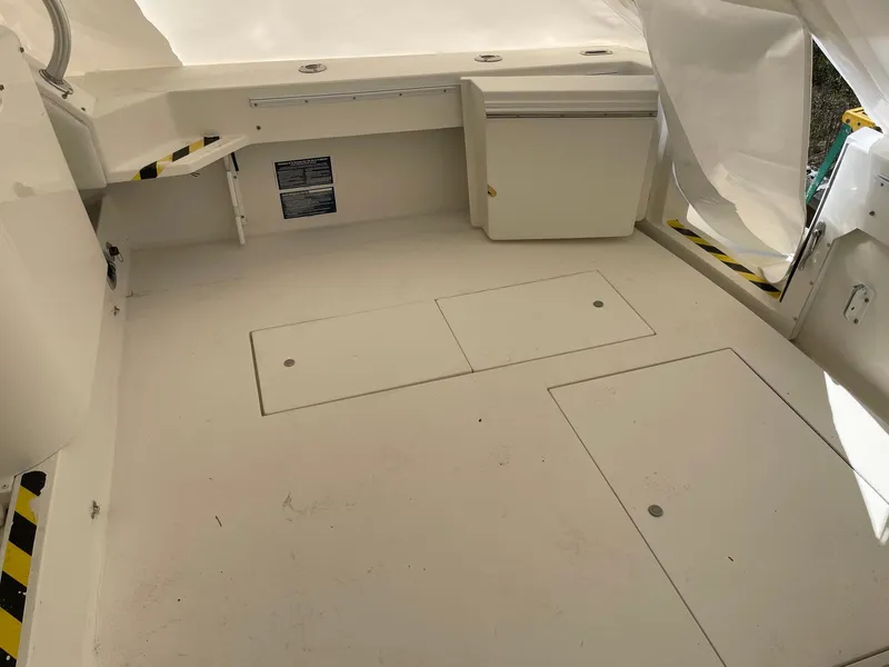 Slide: The Image of 2000 Wellcraft 330 Coastal boat interior with storage compartments and seating area. - 25