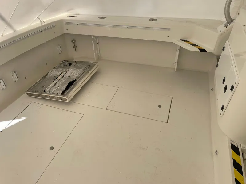 Slide: The Image of 2000 Wellcraft 330 Coastal boat interior, featuring spacious deck and storage compartments. - 26