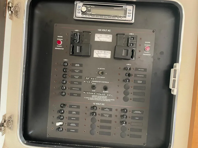 Slide: The Image of Electrical panel of a 2000 Wellcraft 330 Coastal boat, featuring switches and a stereo system. - 7