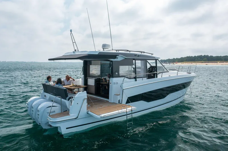 Slide: The Image of 2025 Jeanneau NC 1295 Coupe cruising on open water with passengers enjoying the view. - 3