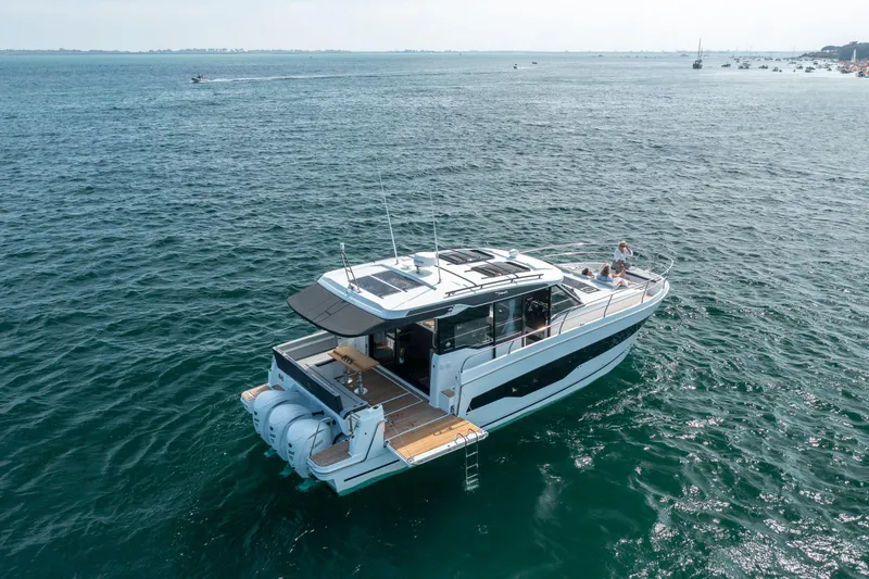 Slide: The Image of 2025 Jeanneau NC 1295 Coupe cruising on open water, showcasing sleek design and luxury features. - 6