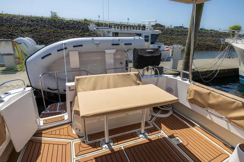 Slide: The Image of 2023 Ranger Tugs R-31 S boat deck with seating and table, docked at marina. - 1