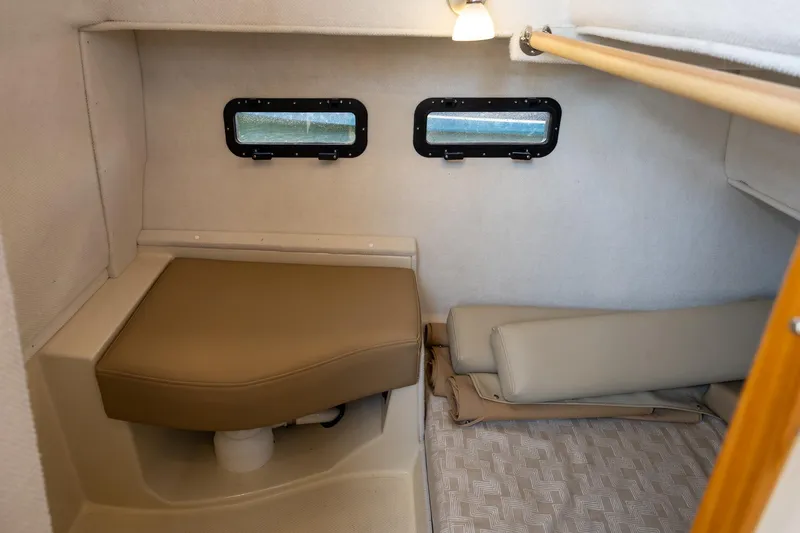 Slide: The Image of 2023 Ranger Tugs R-31 S cabin interior with beige seating and dual windows. - 10