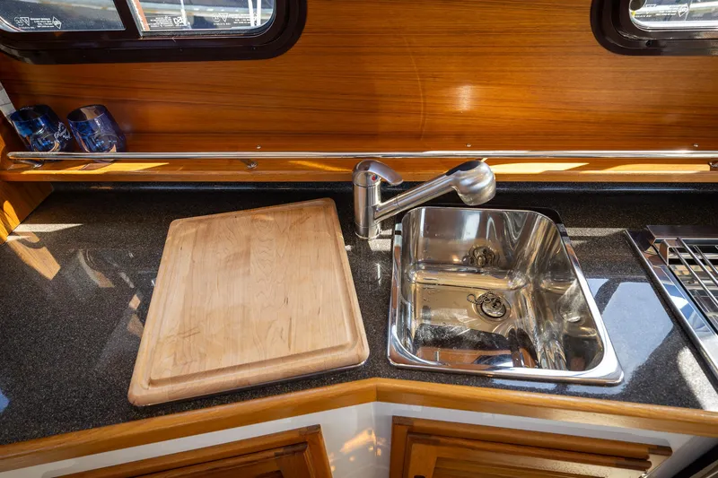 Slide: The Image of 2023 Ranger Tugs R-31 S kitchen with sink and cutting board. - 16