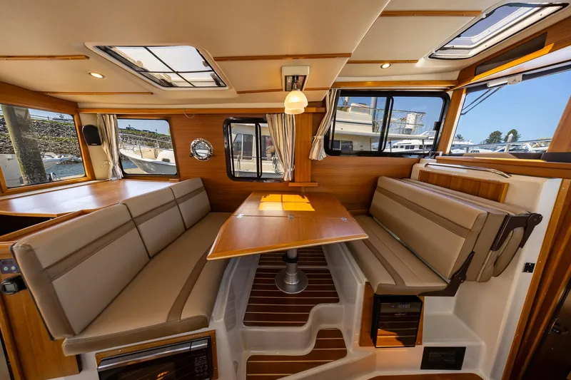 Slide: The Image of 2023 Ranger Tugs R-31 S interior with wood accents and spacious seating area. - 19