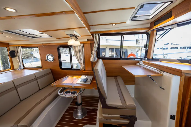 Slide: The Image of 2023 Ranger Tugs R-31 S interior with elegant seating and wooden accents. - 20