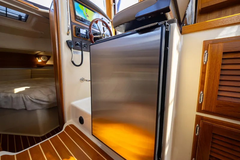 Slide: The Image of 2023 Ranger Tugs R-31 S interior with stainless steel fridge and cozy cabin. - 22