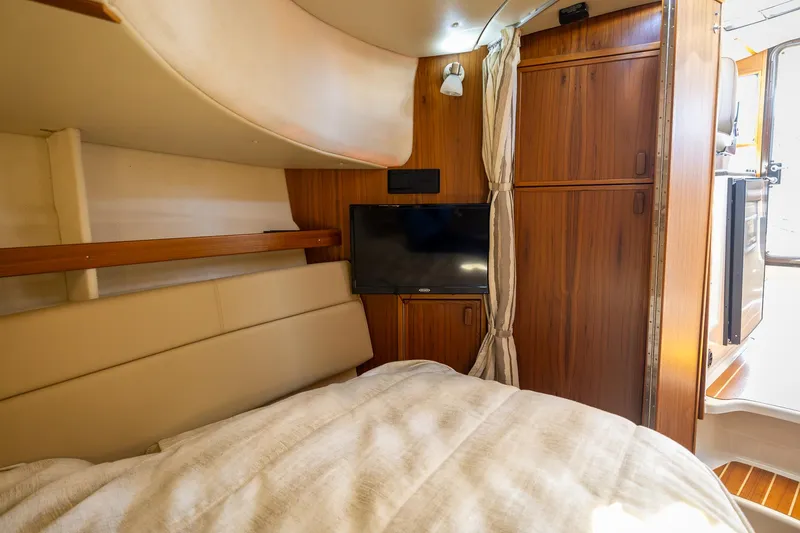 Slide: The Image of 2023 Ranger Tugs R-31 S interior cabin with TV and wooden cabinetry. - 29