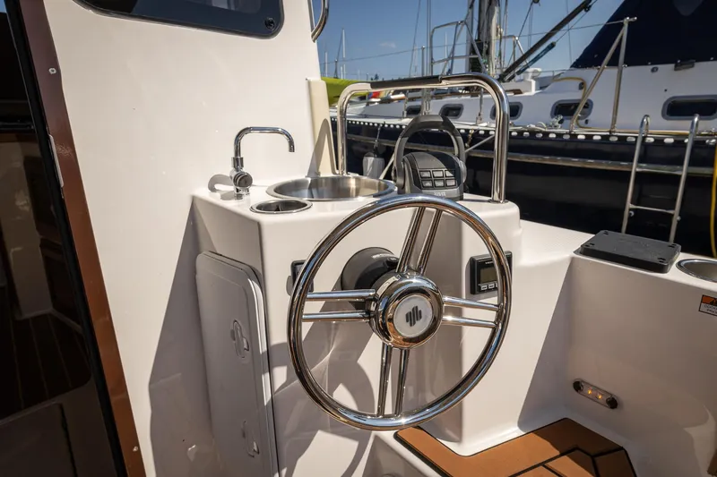Slide: The Image of 2023 Ranger Tugs R-31 S helm with stainless steel wheel and sink. - 6