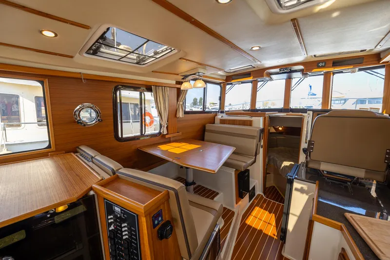 Slide: The Image of Interior of 2023 Ranger Tugs R-31 S, featuring elegant wood finishes and spacious seating. - 7