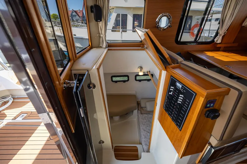 Slide: The Image of 2023 Ranger Tugs R-31 S interior with wood accents and control panel. - 9