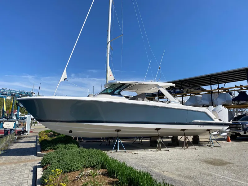 Slide: The Image of 2025 Tiara Yachts 43 LS on display, sleek design, blue and white hull, outdoor setting. - 0