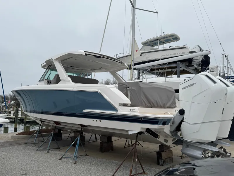 Slide: The Image of 2025 Tiara Yachts 43 LS boat with Mercury engines, docked at a marina. - 1