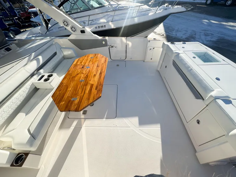 Slide: The Image of 2025 Tiara Yachts 43 LS boat deck with wooden table and white seating. - 12